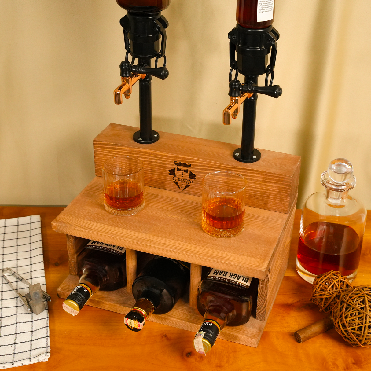 Wooden drink dispenser with bottles and glasses on a wooden surface.