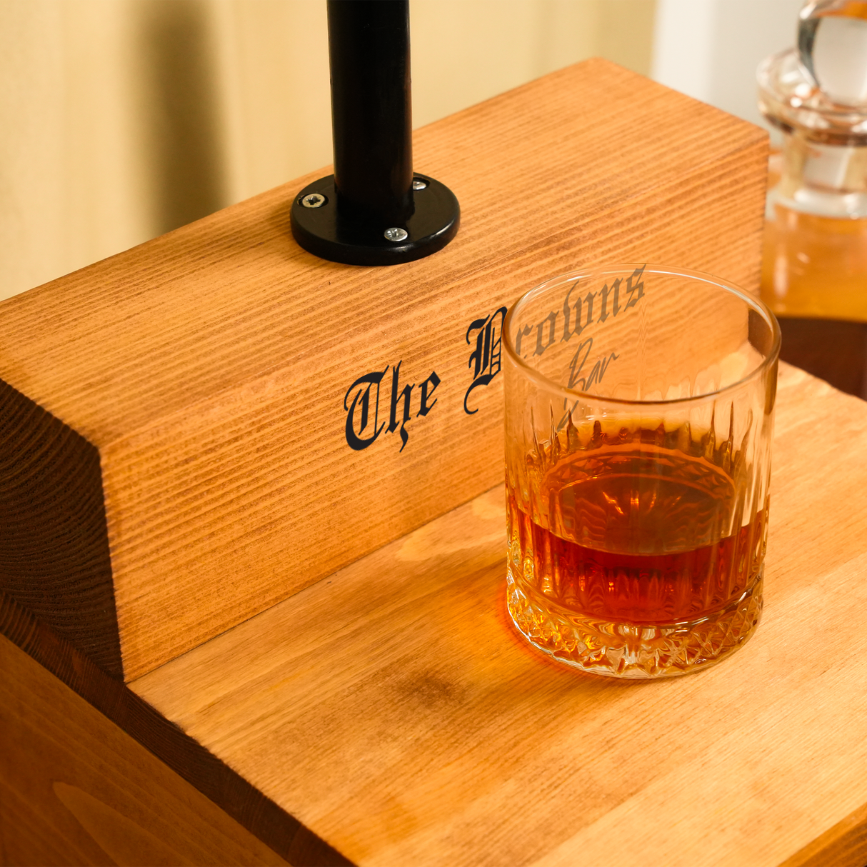 Glass of whiskey on a wooden coaster with 'The Whisky Co' branding.