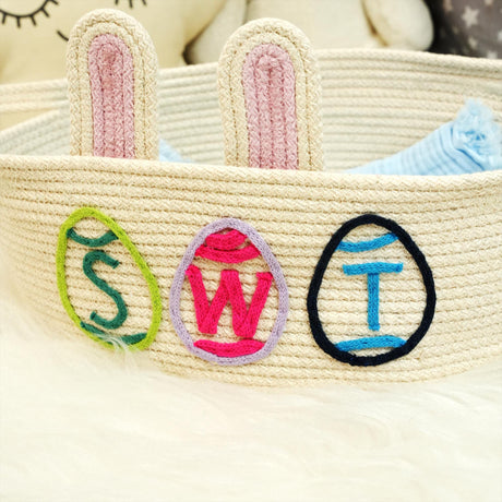 a crocheted basket with a stuffed animal in the background