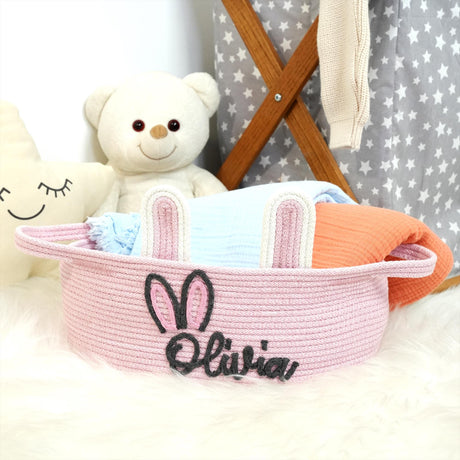 a teddy bear sitting next to a pink basket