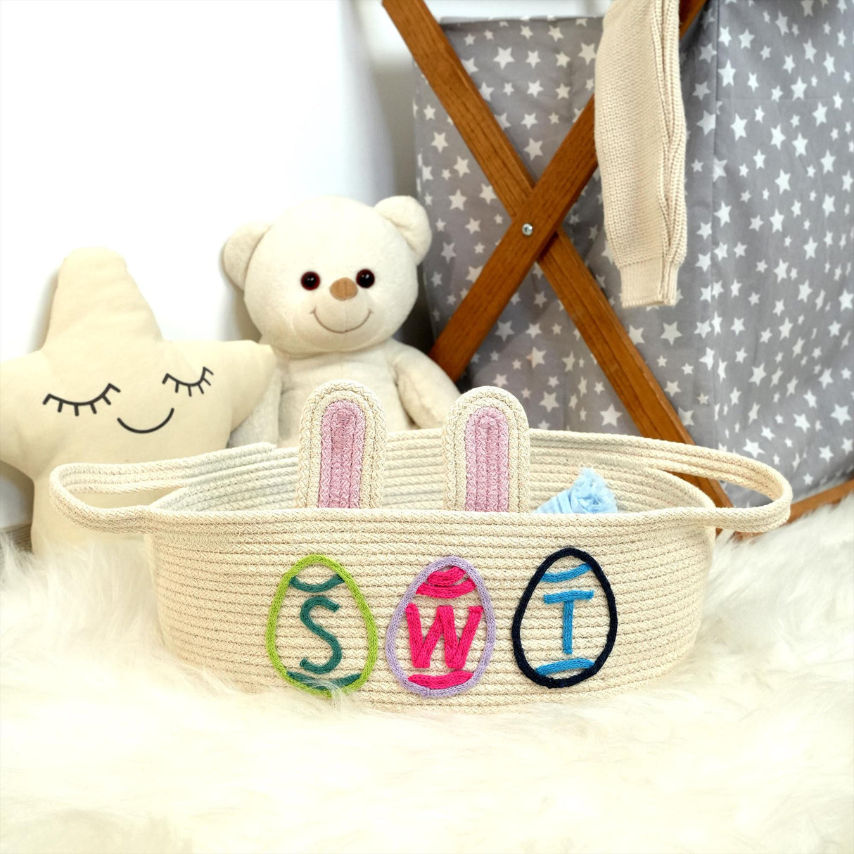 a teddy bear sitting next to a basket with a name on it