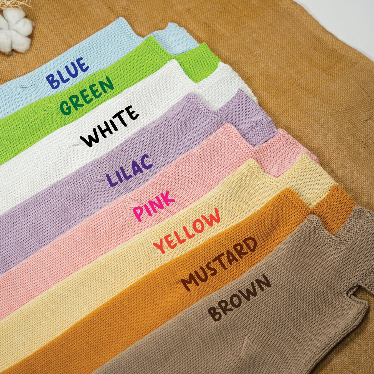 knitted dresses in 8 different colors standing on a table