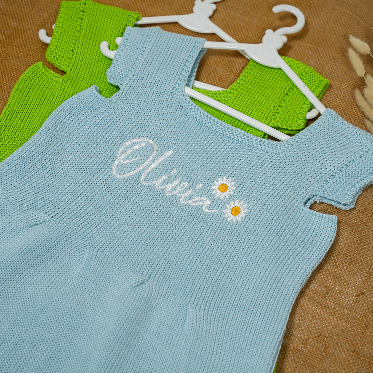 knitted dresses in blue and green standing on a table