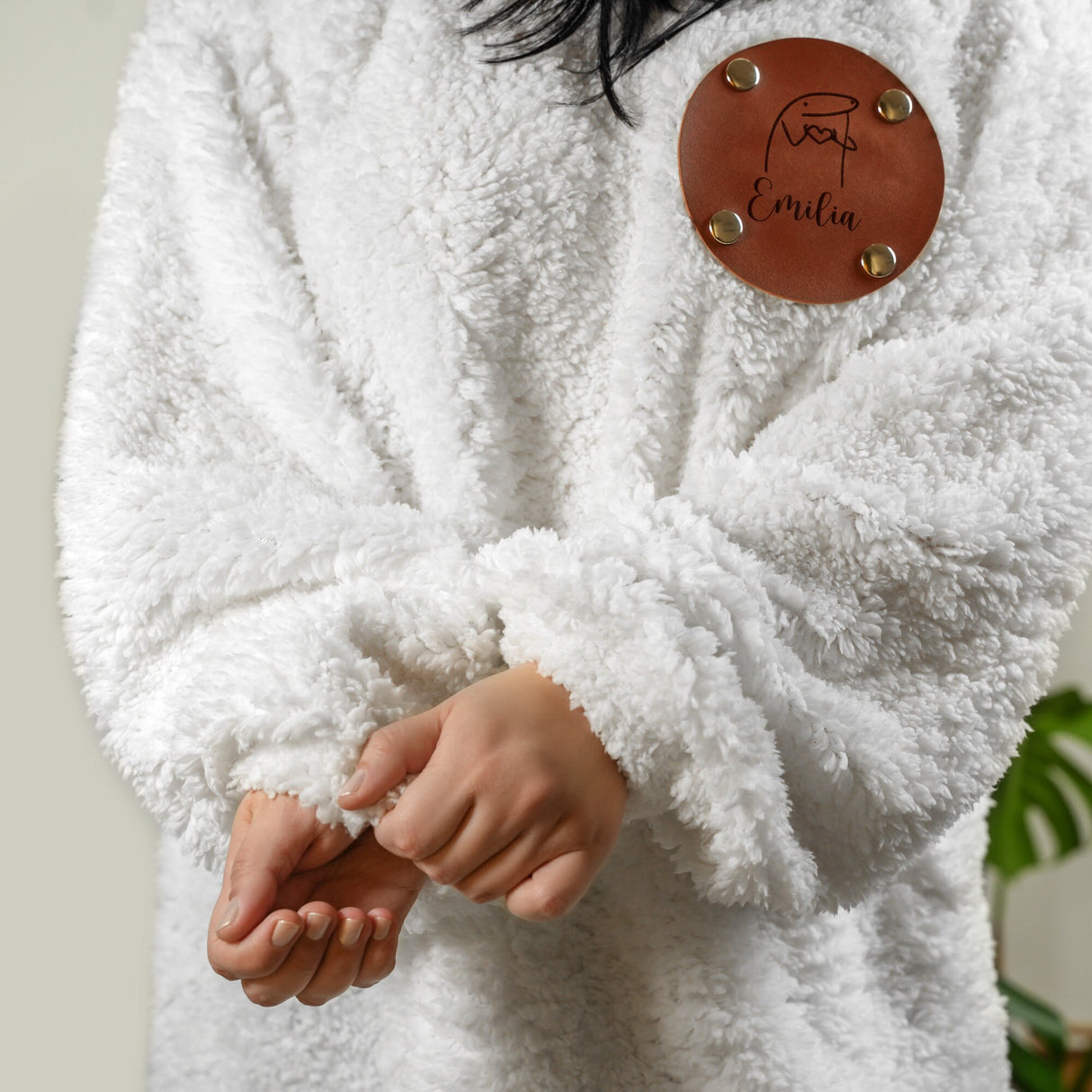 a woman wearing a white coat with a leather button
