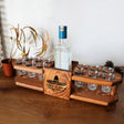 a wooden tray with glasses and a bottle on it