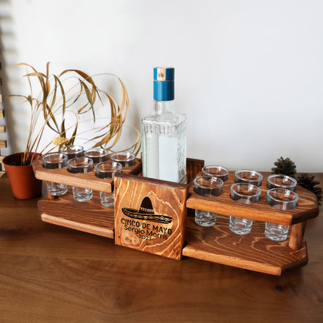a wooden tray with glasses and a bottle on it