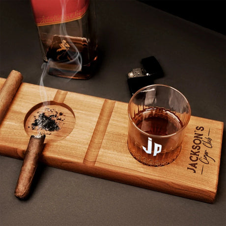 a cigar and a glass of whiskey on a wooden tray