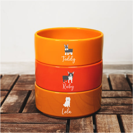 a stack of three orange bowls sitting on top of a wooden table