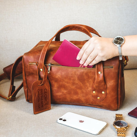 a woman's hand is holding a wallet and a purse