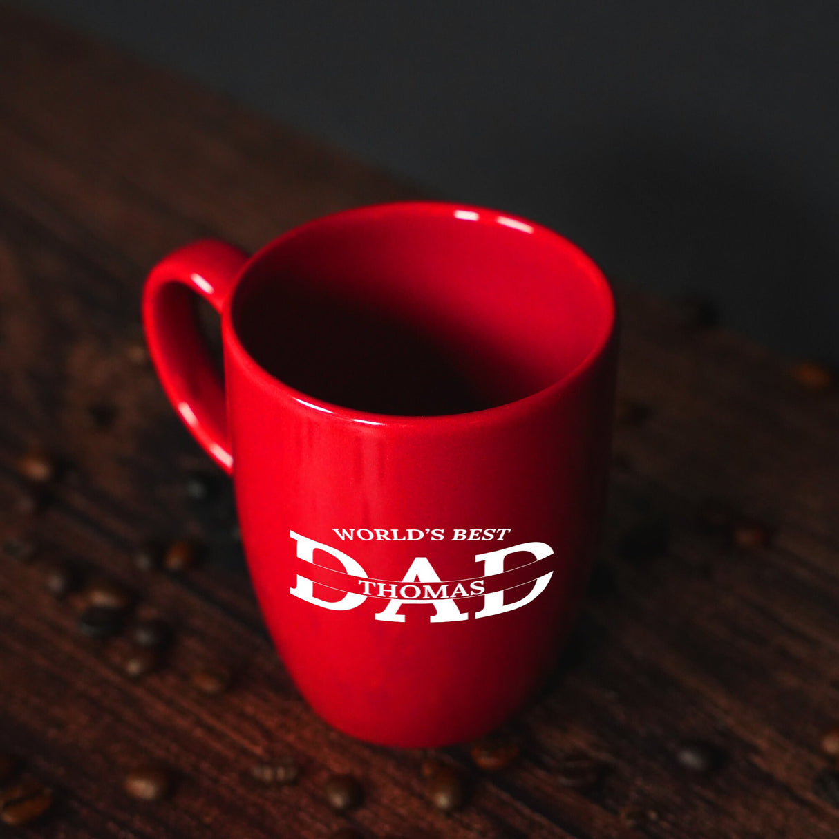 a red coffee mug sitting on top of a wooden table