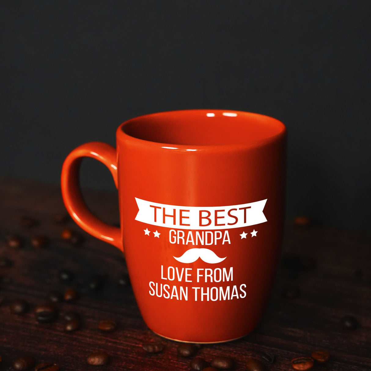 a red coffee mug sitting on top of a wooden table