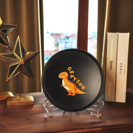 a black plate with a picture of a dinosaur on it