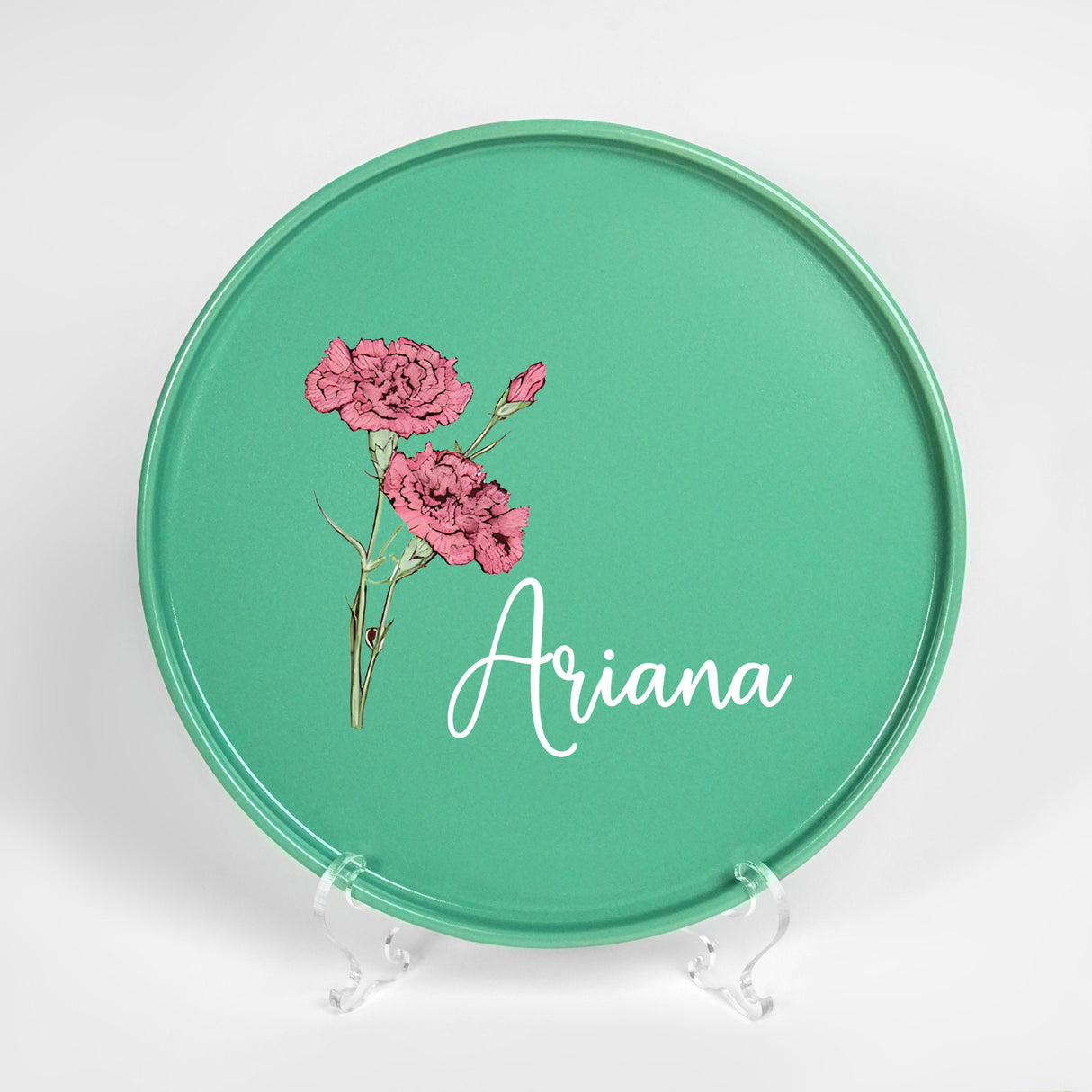 a green plate with pink flowers painted on it