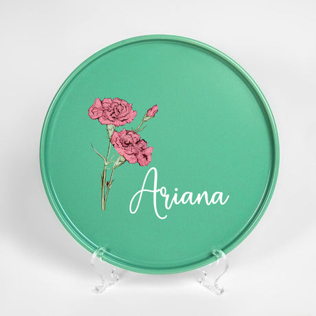 a green plate with pink flowers painted on it