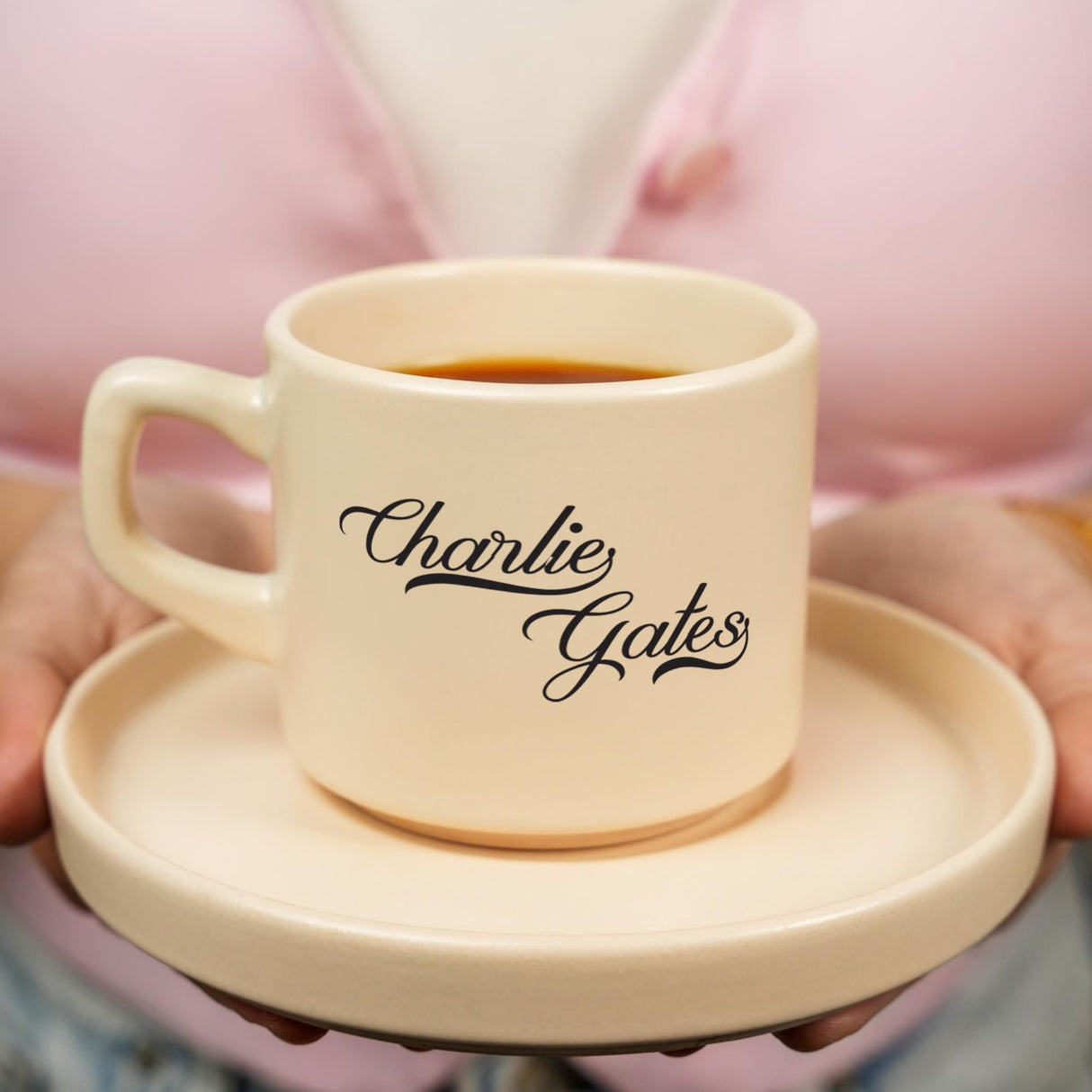 a woman holding a cup of coffee on a plate