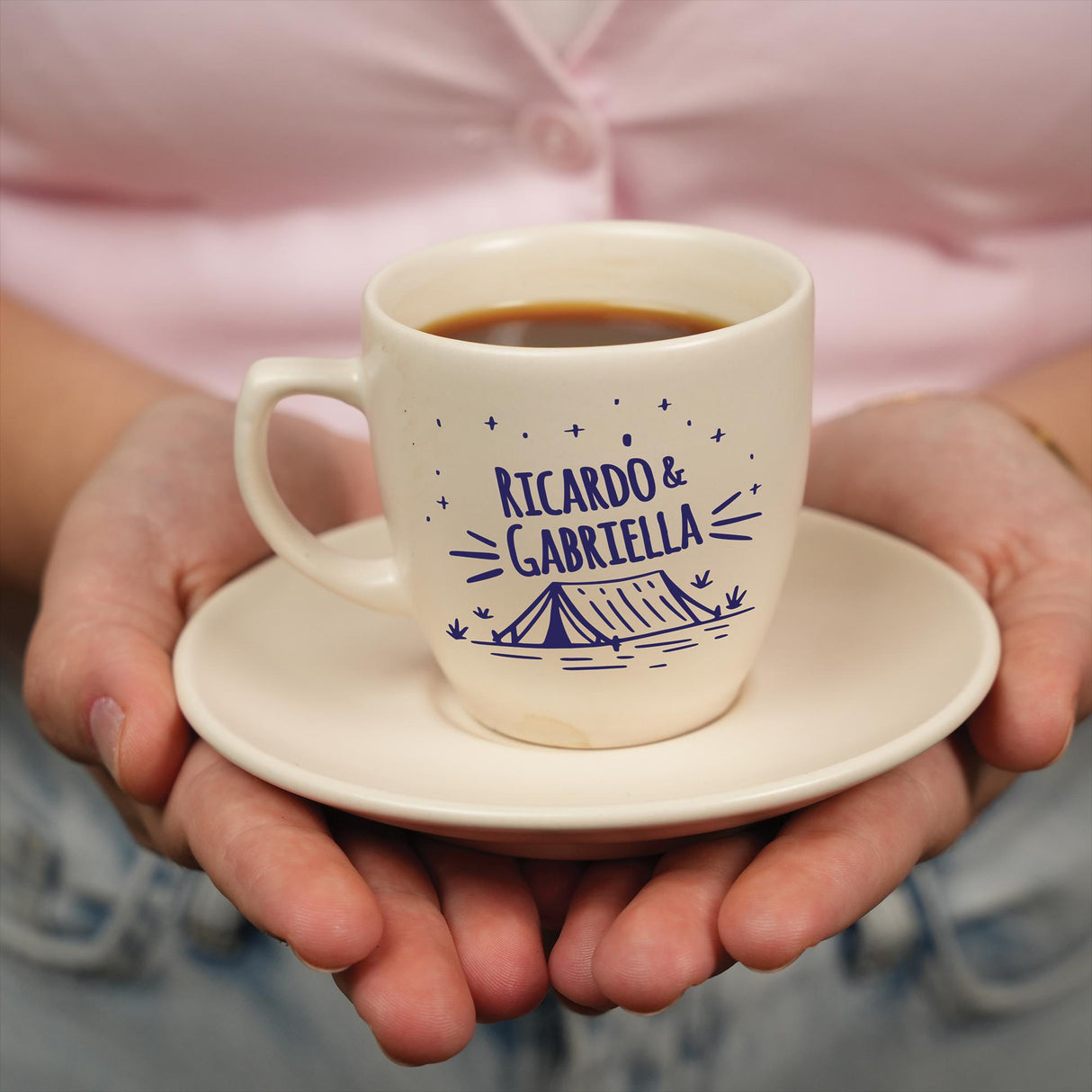 a person holding a cup of coffee in their hands