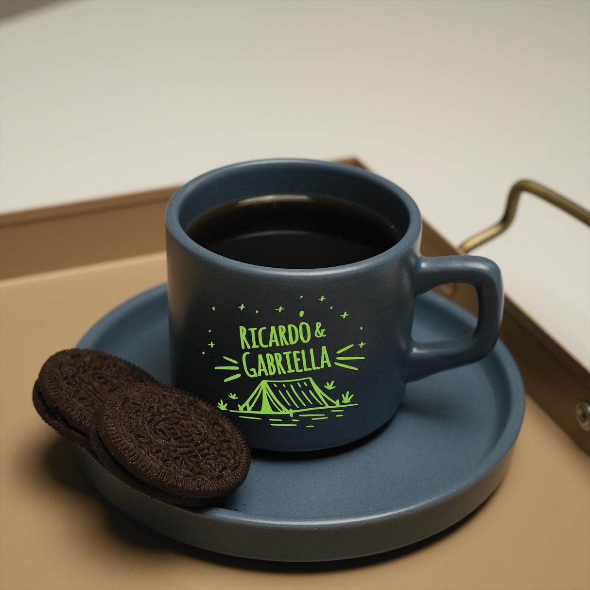 a cup of coffee and a cookie on a tray