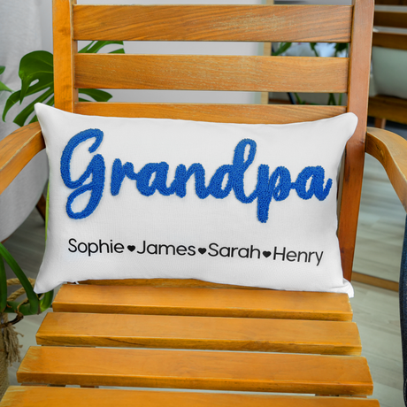 a wooden chair with a pillow that says grandpaa