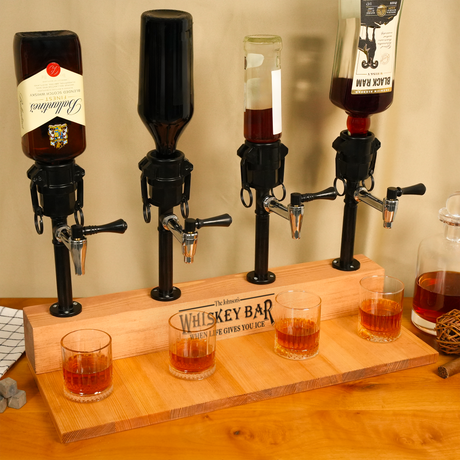 Whiskey tasting setup with four dispensers and glasses on a wooden board labeled 'Whiskey Bar'.