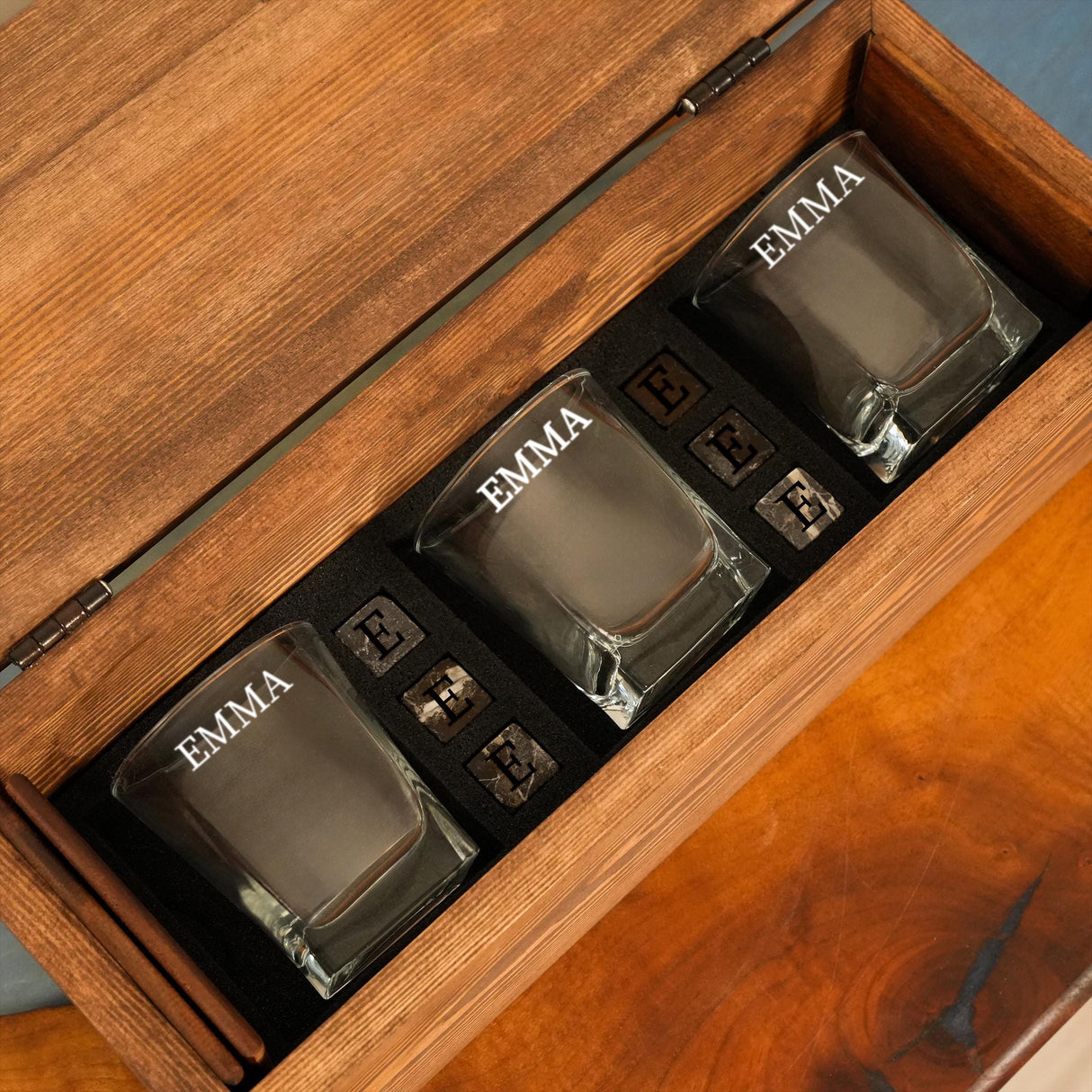 three shot glasses in a wooden box on a table