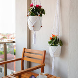 a wooden bench sitting next to a white hanging planter