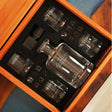 a couple of glass bottles sitting inside of a wooden box