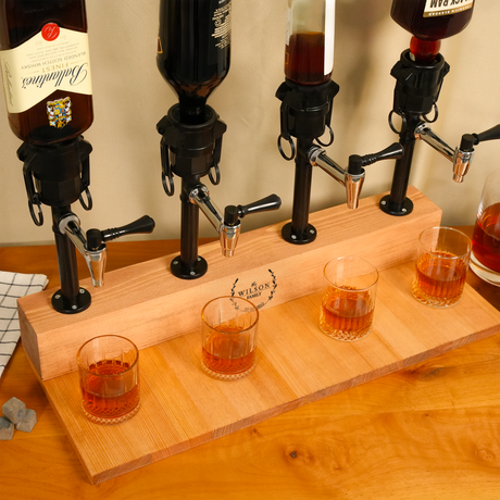 Wooden beer flight with four taps and glasses filled with amber liquid on a wooden surface.