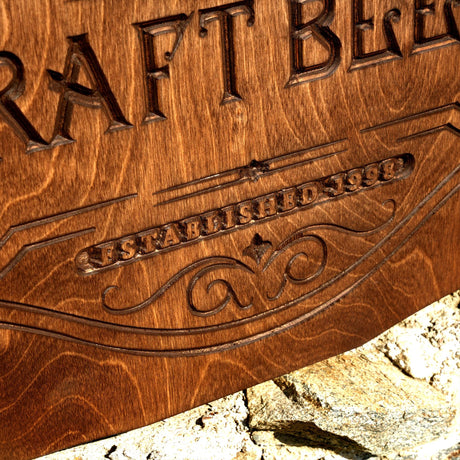 a close up of a wooden sign on a rock