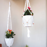 two hanging planters with flowers in them