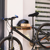 close-up of a wall-mounted bicycle holder with bicycle and helmet on it