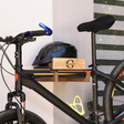 close-up of a wall-mounted bicycle holder with bicycle and helmet on it