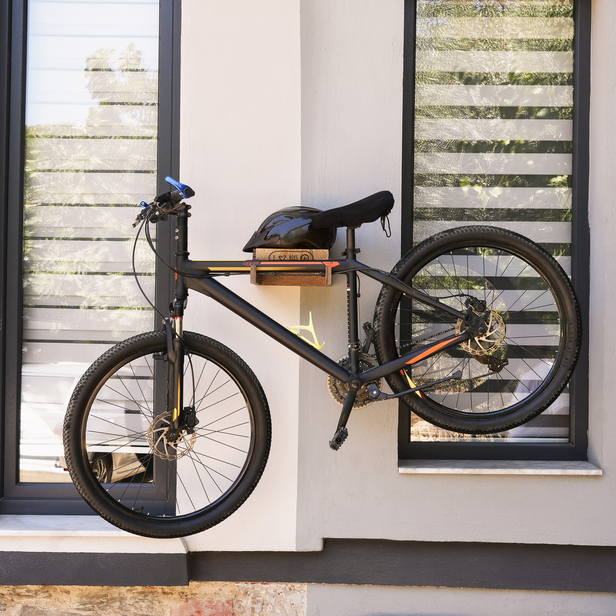 a wall-mounted bicycle holder with bicycle and helmet on it