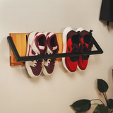 a wall-mounted shoe rack with two pairs of shoes on it