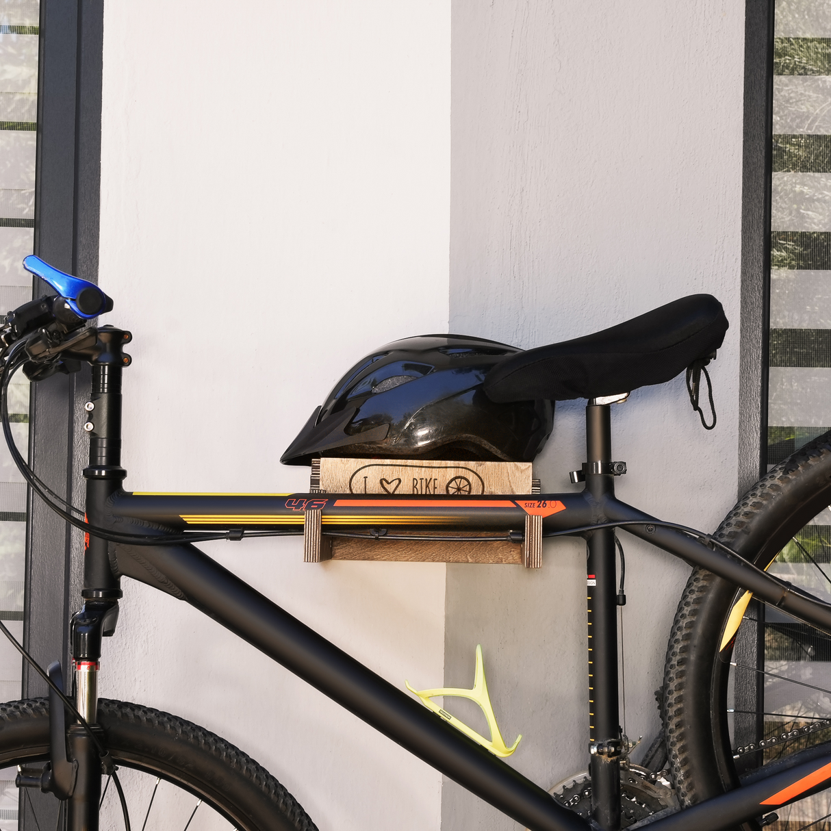 close-up of a wall-mounted bicycle holder with bicycle and helmet on it