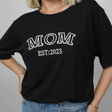 a woman with blonde hair, wearing a mom t-shirt