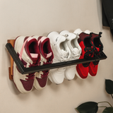 close-up of a shoe rack hanging on the wall with three shoes on it