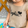 a girl in a brown dress playing a puzzle