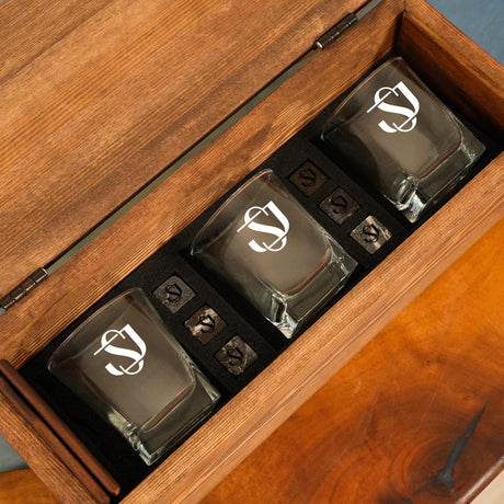 three shot glasses in a wooden box on a table