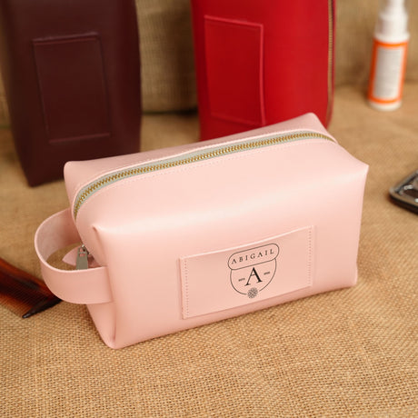 a pink bag sitting on top of a table next to a cell phone