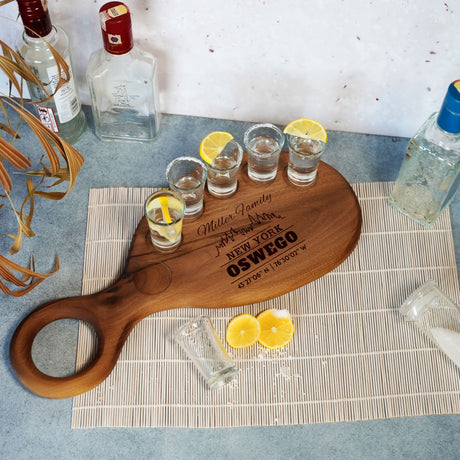 a wooden cutting board with glasses and lemons on it