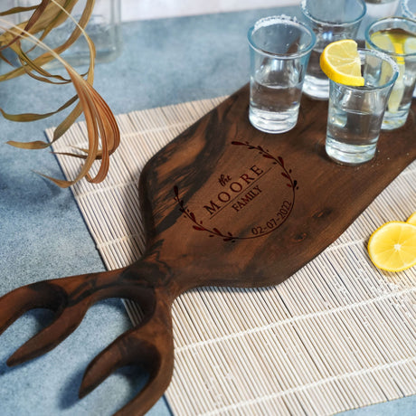 a wooden cutting board with glasses and lemons on it