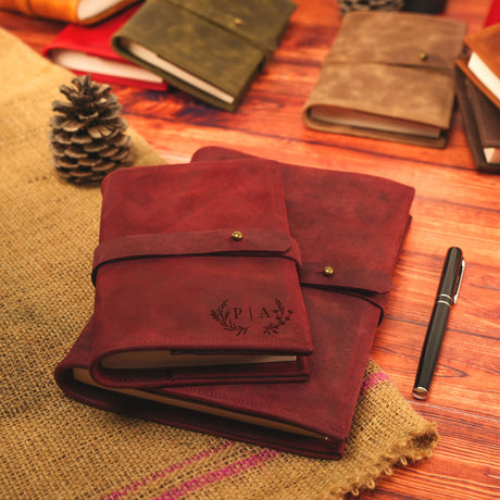 a wooden table topped with notebooks and a pen