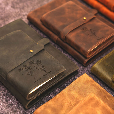 a collection of leather notebooks sitting on a carpet