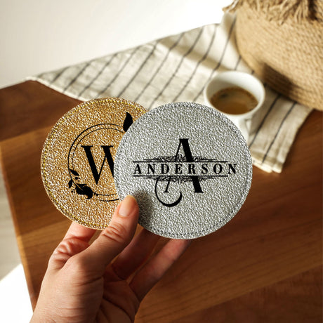 a person holding a coaster with a monogrammed logo on it