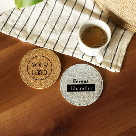 two coasters sitting on top of a wooden table next to a cup of coffee