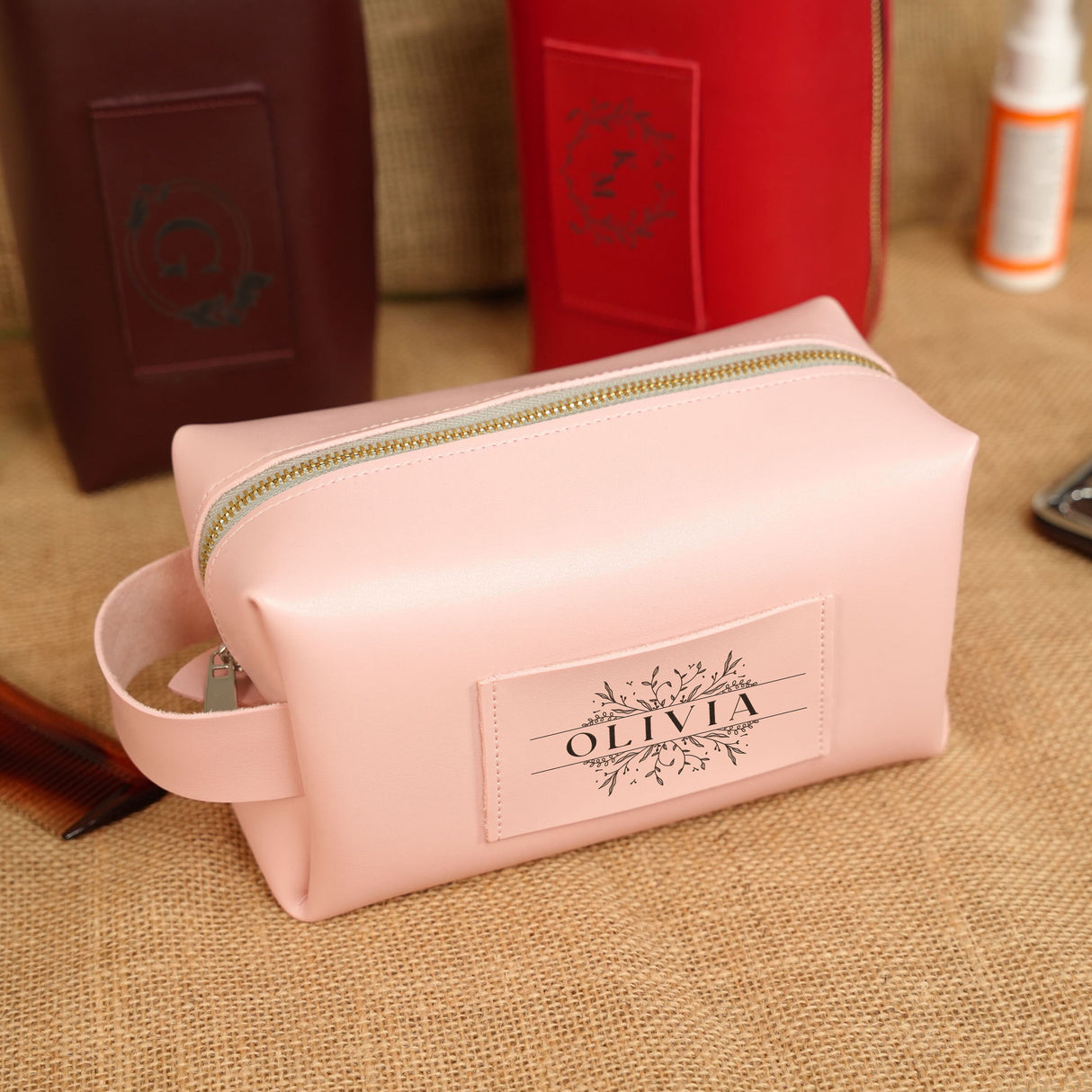 a pink bag sitting on top of a table next to a cell phone