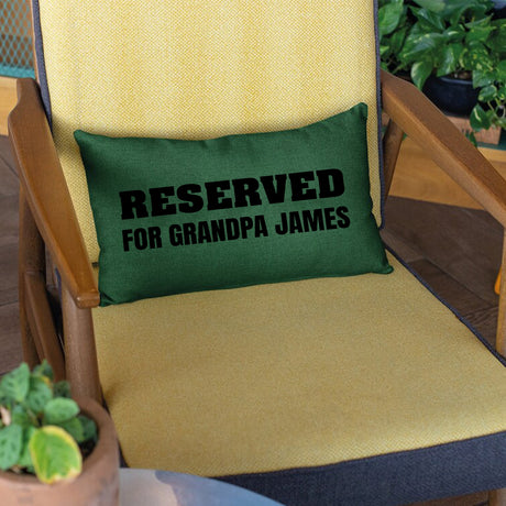 a green pillow that reads reserved for grandpa james