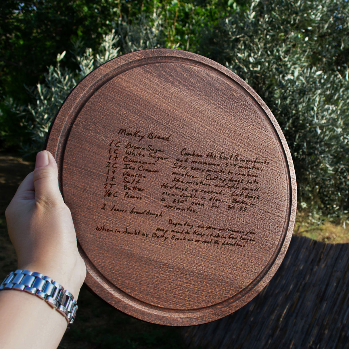 a person holding a wooden plaque with writing on it