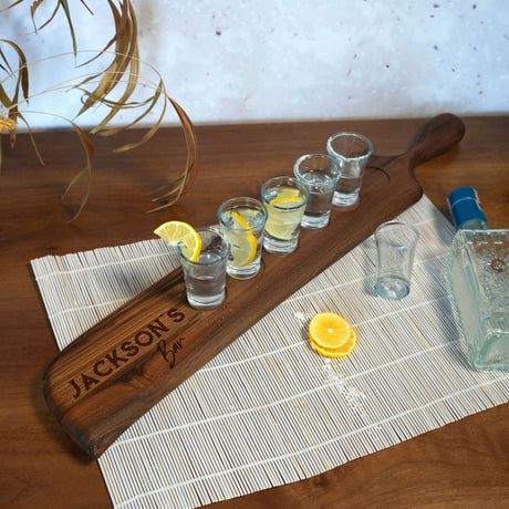 a wooden paddle sitting on top of a table next to glasses