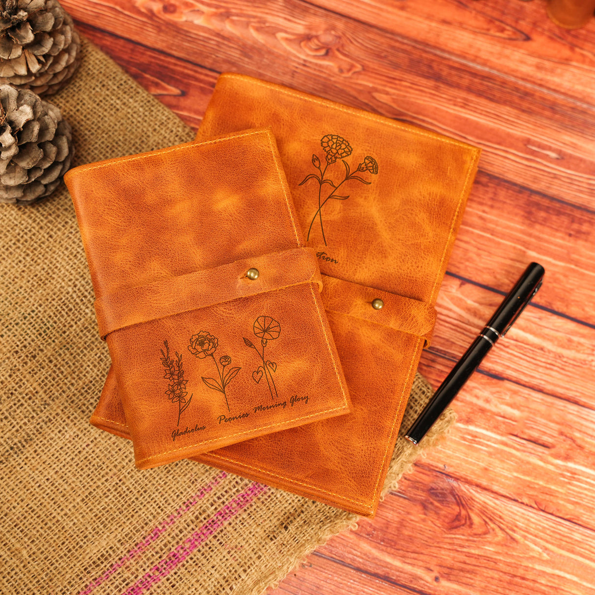 a pair of notebooks sitting on top of a wooden table